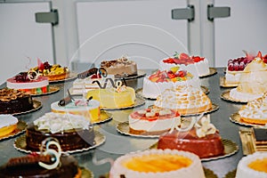 Many cakes prepared on the metal table of a food factory