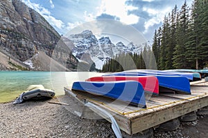 Many Canoes on wooden deck at Moraine lake in Banff national park