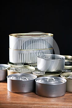 Many cans of canned tuna and sardine on brown wood