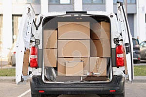 Many cardboard boxes lying in minibus with open door