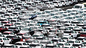 Many cars at a dealership yard at a port in Reunion, waiting to get through customs