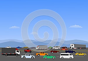 Many cars are driving on highways with mountains and blue sky in the background