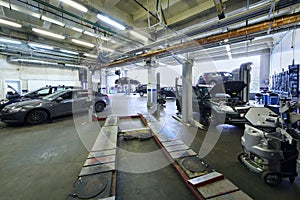 Many cars stand in car garage with special equipment