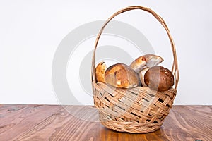 many ceps in basket isolated on wooden table and white background