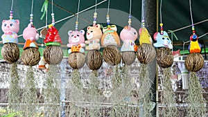 Many ceramic doll hanging containing spanish moss (Tillandsia us