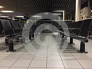 The many chairs at an empty hall at the airport at night