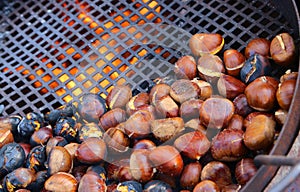 many chestnuts roasted in giant pan on the fire from a street vendor