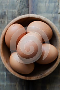 Many chicken eggs in a wooden bowl on burlap on a wooden background. Rustic style. The concept of organic food.