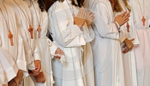 Many children with long white tunic during the first communion