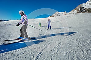 Many children ski on the hill together downhill