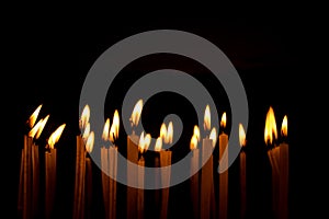 Many christmas candles burning at night on the black background