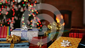 Many christmas gifts in front of fireplace and blurry lights on xmas tree