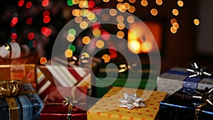 Many christmas gifts in front of fireplace and blurry lights on xmas tree