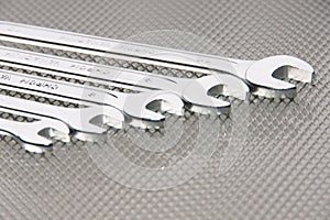 Many chrome-plated wrenches and metalic background