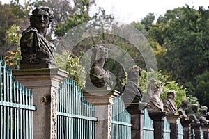 Row of busts on pillars in ancient fence photo