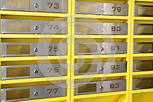 Many closed metal mailboxes with keyholes and numbers as background