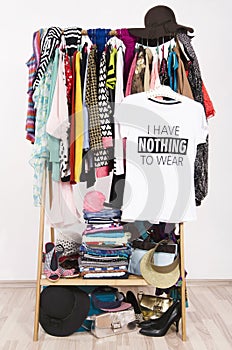 Many clothes on the rack with a t-shirt saying nothing to wear.