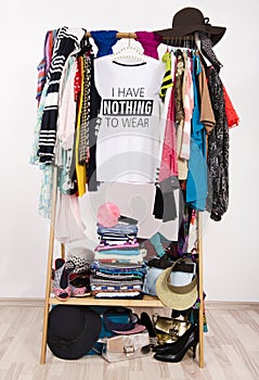 Many clothes on the rack with a t-shirt saying nothing to wear.