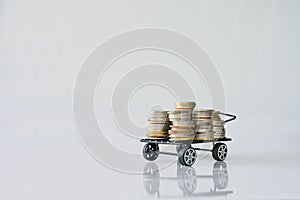 Many coins in the blue shopping cart Isolated on white background and copy space, saving and investment concept