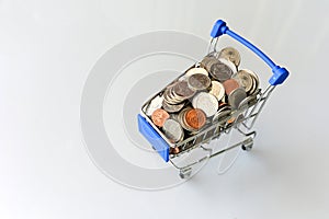 Many coins in the blue shopping cart Isolated on white background and copy space, saving and investment concept