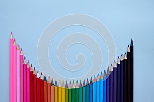 Many color pencils wave on grey background, flatlay. Back to school