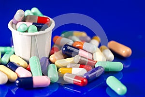 Many Colored Capsules With Medication Cup