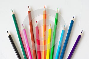 Many colored pencils lie on a white background. Copy spase. The concept of back to school, the educational process, study at