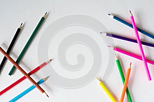 Many colored pencils lie on a white background. Copy spase. The concept of back to school, the educational process, study at