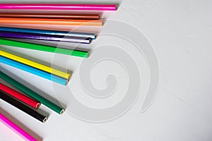 Many colored pencils lie on a white background. Copy spase. The concept of back to school, the educational process, study at