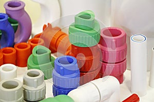 Many colored plugs, screws, valves, fittings, pipes, plastic adapters