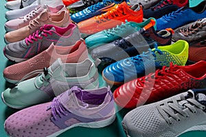 Many colored sports shoes, sneakers and football boots, stand in a row