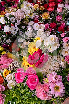 Many colorful artificial fake flowers background blooming beautiful