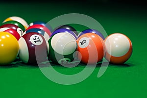 Many colorful billiard balls on green table