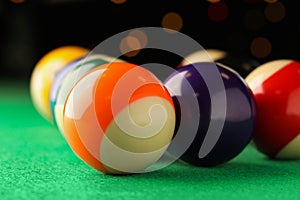 Many colorful billiard balls on green table, closeup