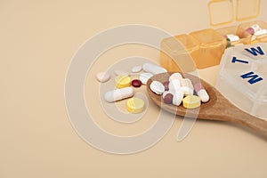 Many colorful drug medicines or pill  in a pillbox on brown table, healthy and medicine concept