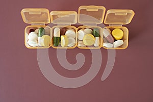 Many colorful drug medicines or pill  in a pillbox on table, healthy and medicine concept