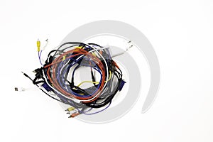 Many colorful electrical cord wires cord cables twist coiled into pile on white background. Top view