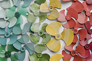 Many colorful Fan blades put on white floor or decorate on white wall background.