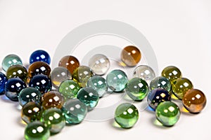 Many colorful glass round beads, balls on a white background close-up