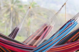 Many colorful hammocks hanging behind each other