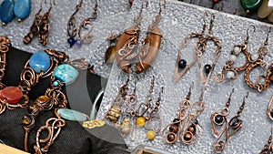 Many colorful handmade earrings for sale at street market fair