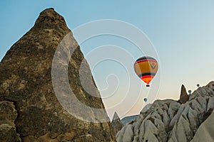 Many colorful hot air balloons flight above mountains - panorama of Cappadocia at sunrise. Wide landscape of Goreme valley