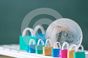 many colorful miniature shopping bags and globe on computer keyboard, online shopping concept