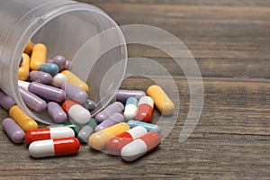 Many Colorful Pills And Capsules Dropped On Wooden Background