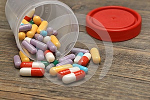 Many Colorful Pills And Capsules Dropped On Wooden Background