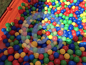 Many colorful plastic balls in a kids` ball. Stock photo