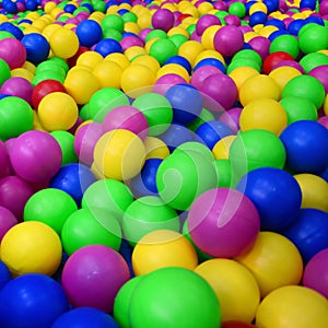 Many colorful plastic balls in a kids& x27; ballpit at a playground.