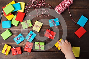 Many colorful small gift boxes with kids hand to take one box