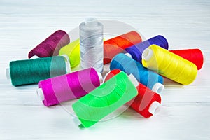 Many colorful threads on white table