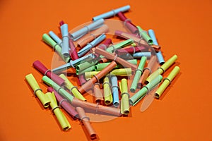 Many colorful tombola tickets lie on an orange underground